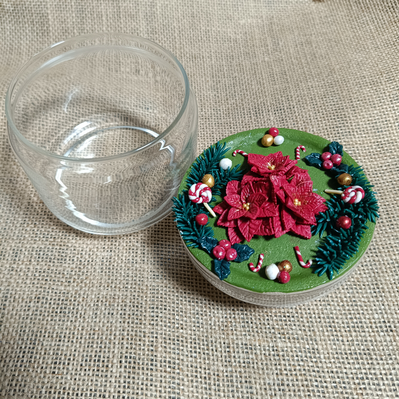 Decorated mug with poinsettia design and candy accents on a green base.