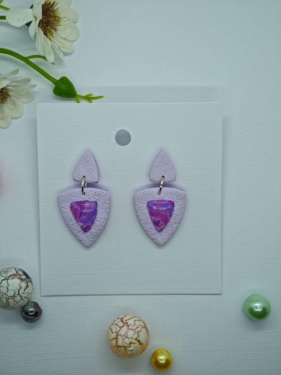 Handmade lavender polymer clay earrings with marbled cabochon accents.