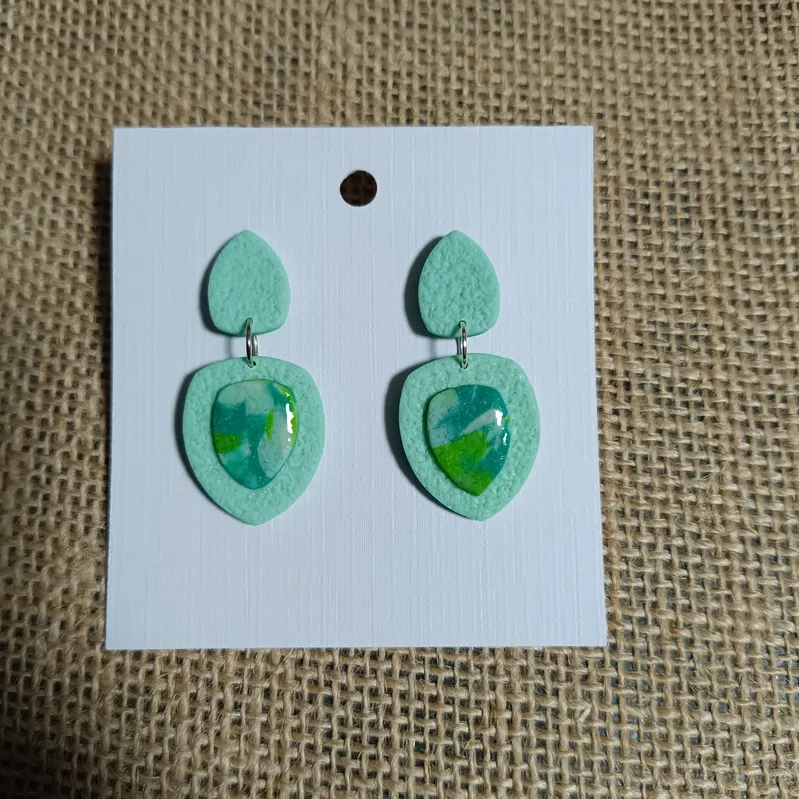 Handmade mint green earrings with marbled cabochon detail.