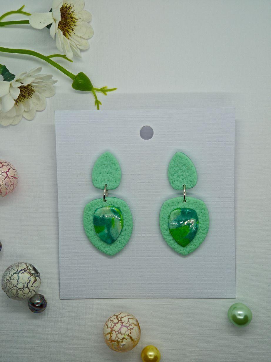 Handmade mint green earrings with a textured finish and a glossy cabochon.