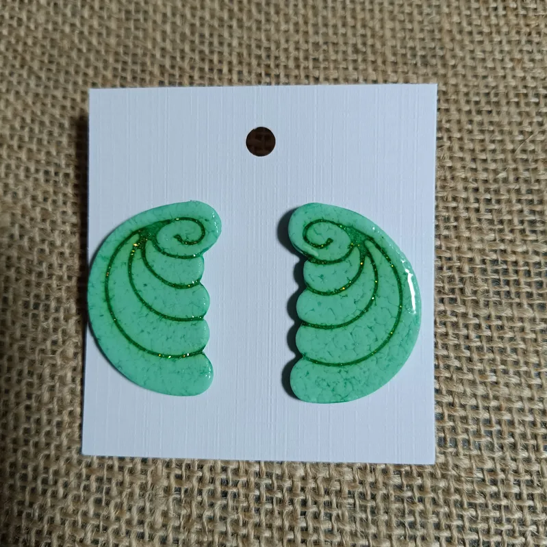 Green spiral-shaped earrings displayed on a card.