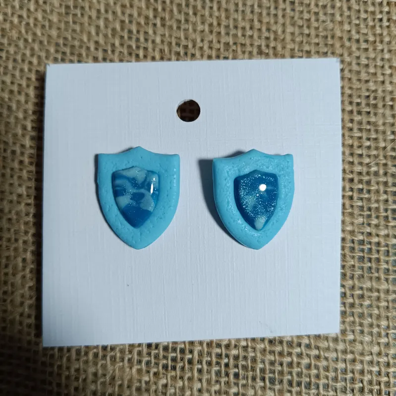 Blue shield-shaped earrings with a glossy finish.