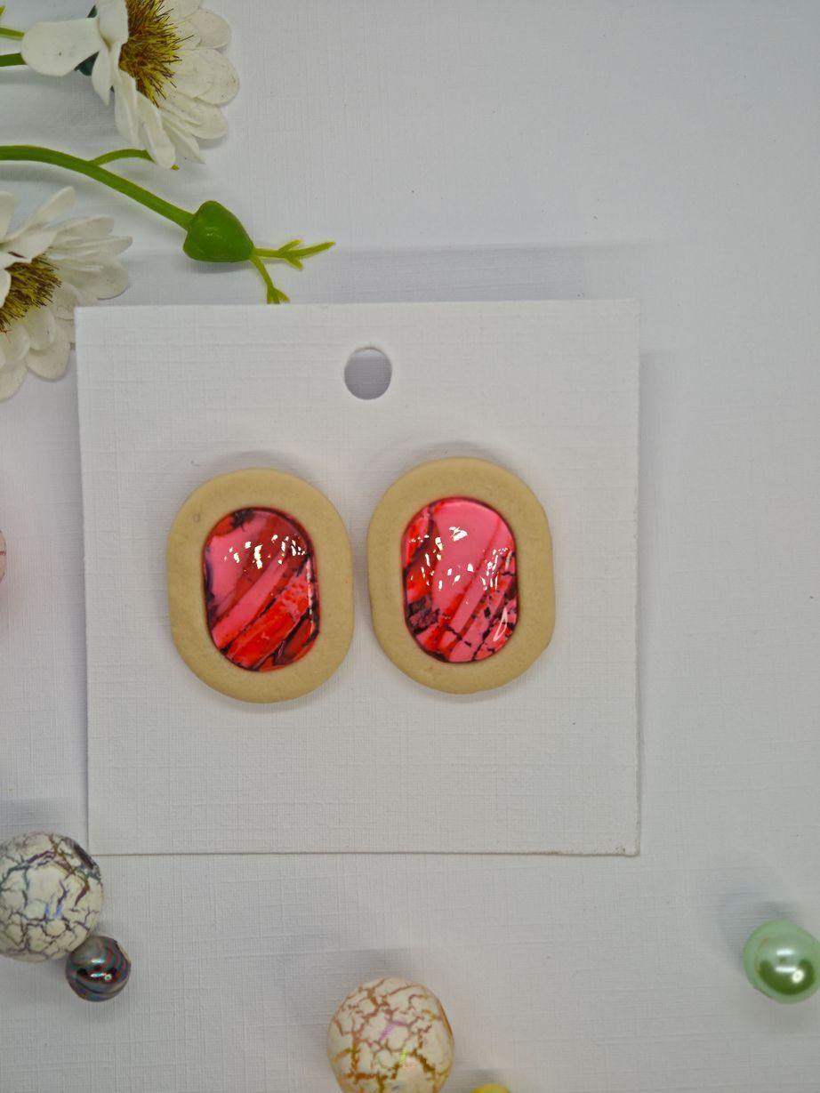 Handmade earrings featuring pink cabochon stones set in a beige polymer clay frame.